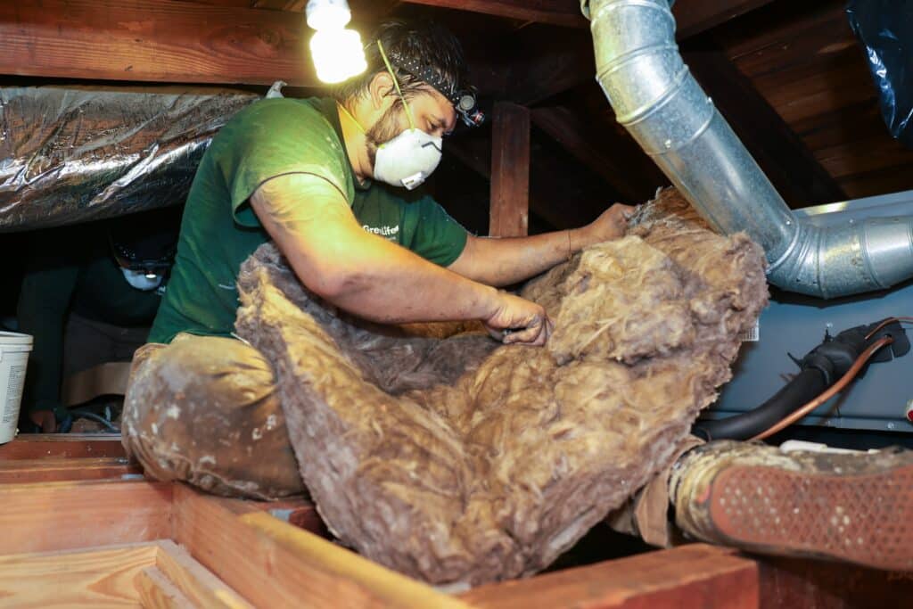 GreenLife Energy Solutions team member installing insulation