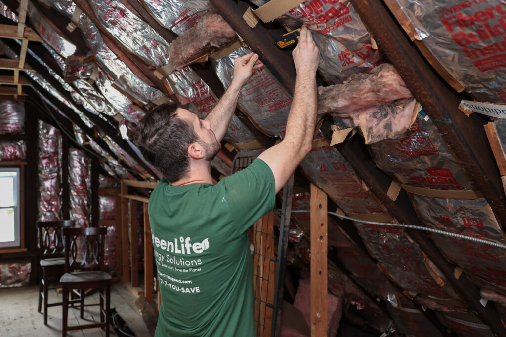 KS7A0180 GreenLife employee installing insulation